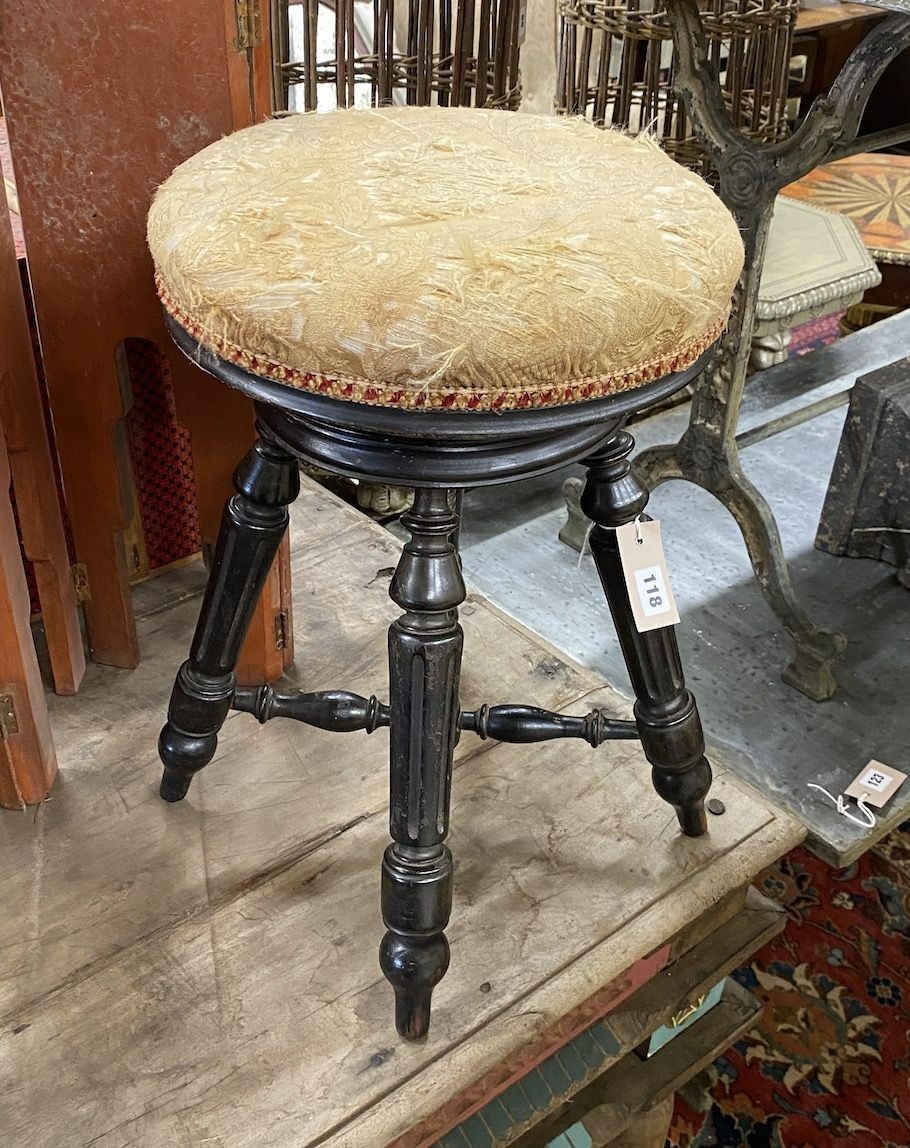 A Victorian ebonised adjustable revolving piano stool